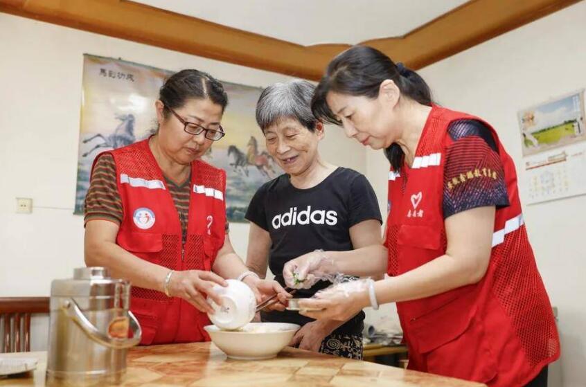 志愿者为居民送上长寿面,传递关怀与祝福。
