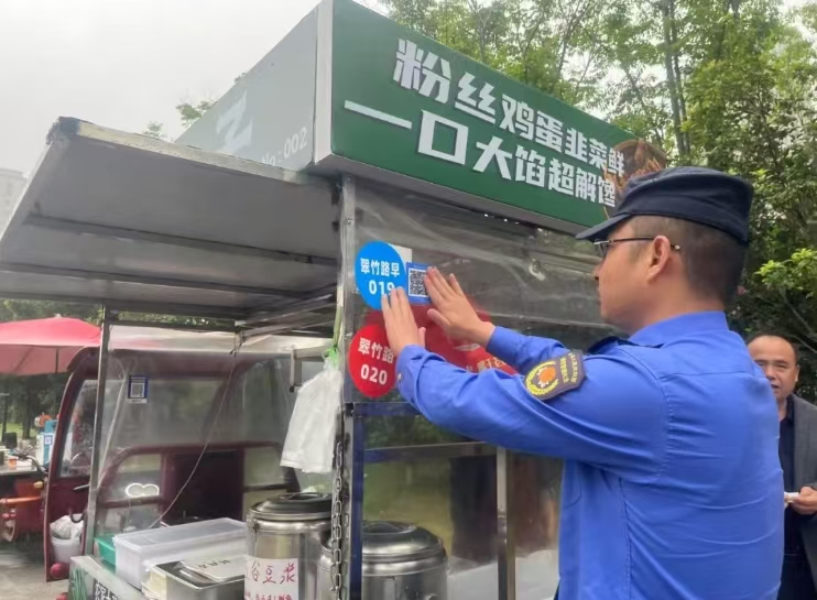 执法人员张贴二维码。肥西县城管局供图