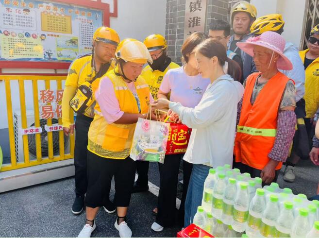 鎮工會副主席陳曉芳給新就業群體發放“愛心禮包”。