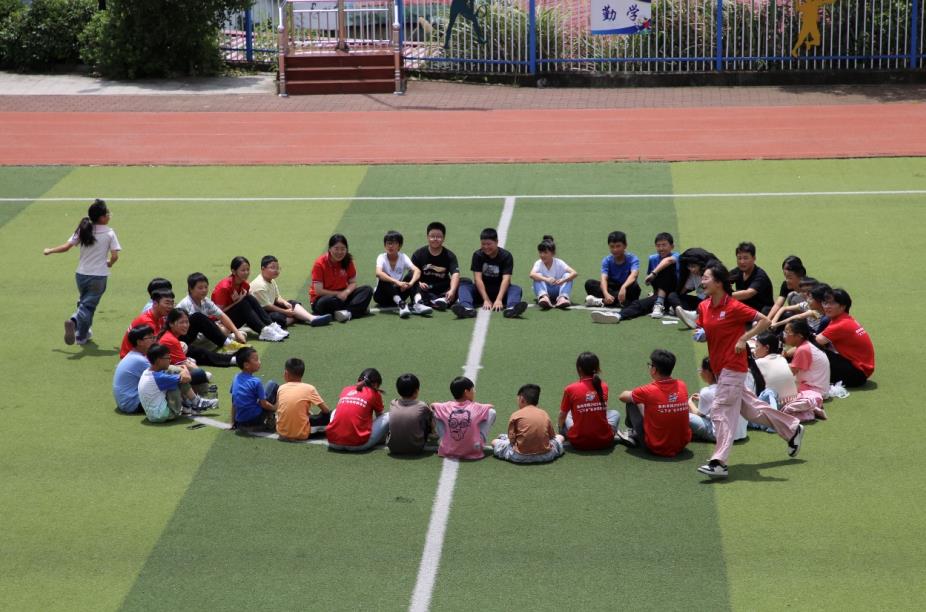 7月9日，金寨县花石实验学校，滁州学院支教队员带领孩子做游戏。曹纯摄