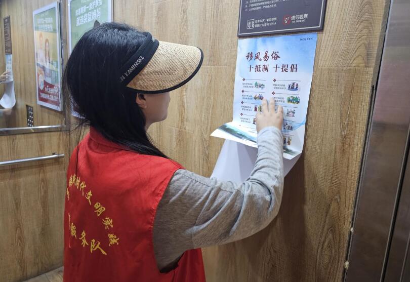 志願者利用電梯廣告欄張貼移風易俗倡議書。靈宣供圖