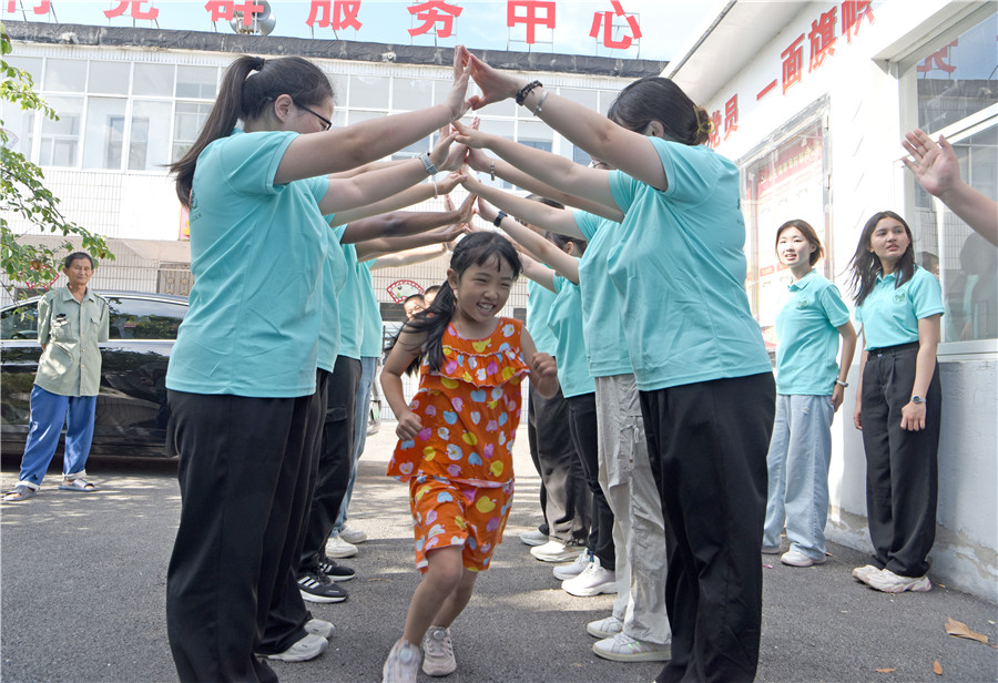 安徽省淮南师范学院外国语学院“节节高升”社会实践团大学生走进淮南市八公山区山王镇林场村与乡村儿童游戏互动。陈彬摄