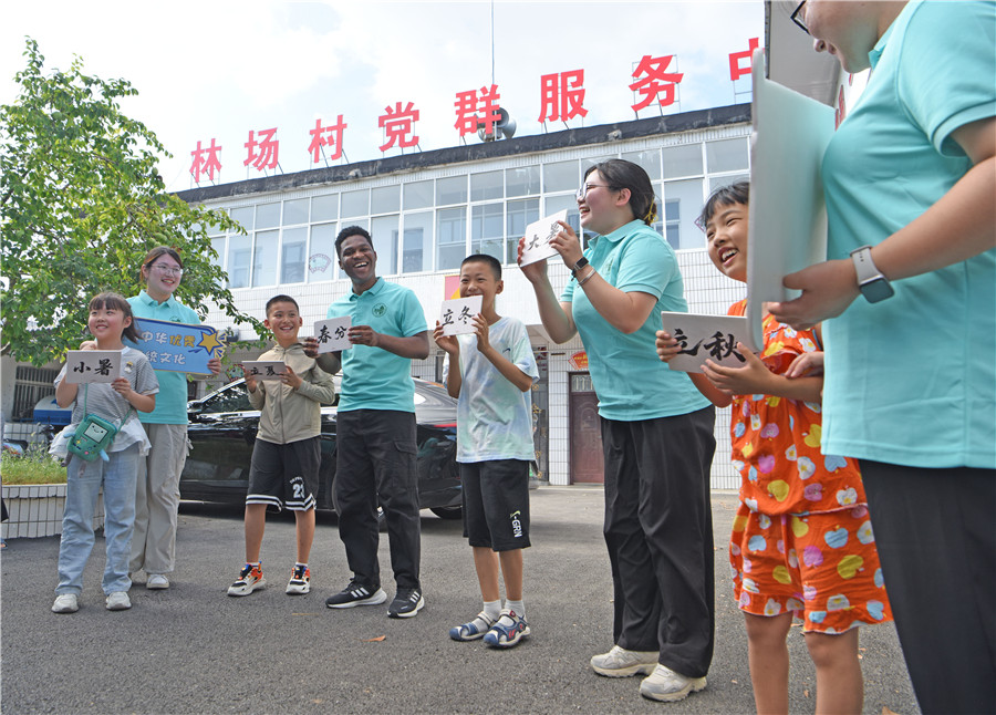 安徽省淮南师范学院外国语学院“节节高升”社会实践团大学生走进淮南市八公山区山王镇林场村与乡村儿童游戏互动。陈彬摄
