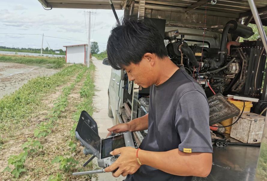 吳盡在操作無人機播種。