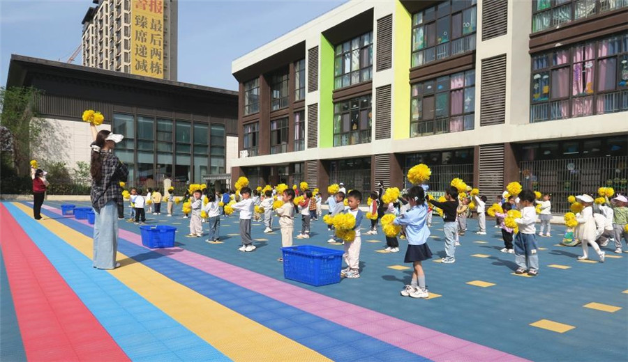 教師帶領幼兒開展戶外活動。