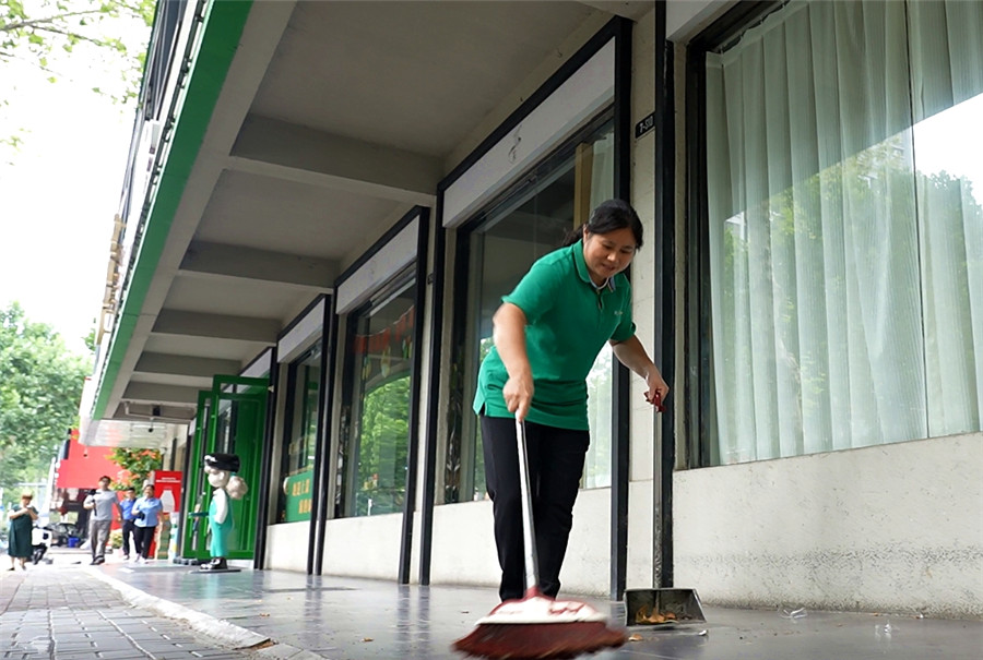 颍上路与凤淮路交口一餐饮店门口,服务员正熟练打扫门前卫生。