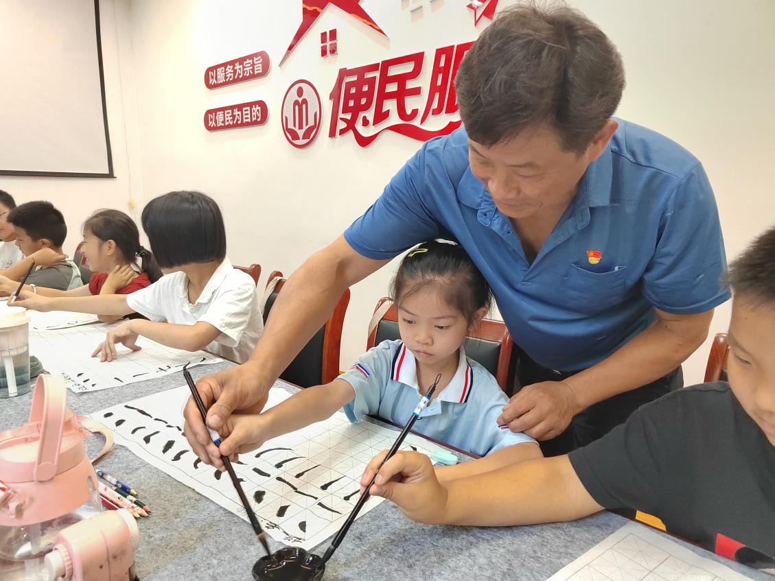 阿奎利亚社区“流星之家”内,流动党员张武胜正在教授孩子们练习书法。孙晓阳摄