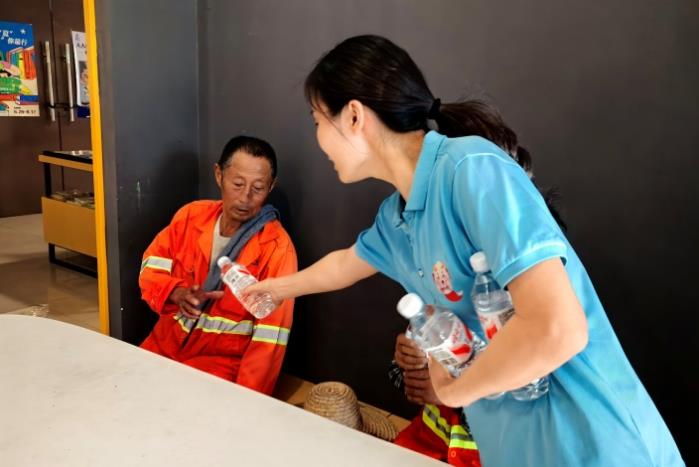 芜湖新华书店湾沚区图书城店工作人员为环卫工人送上饮用水。