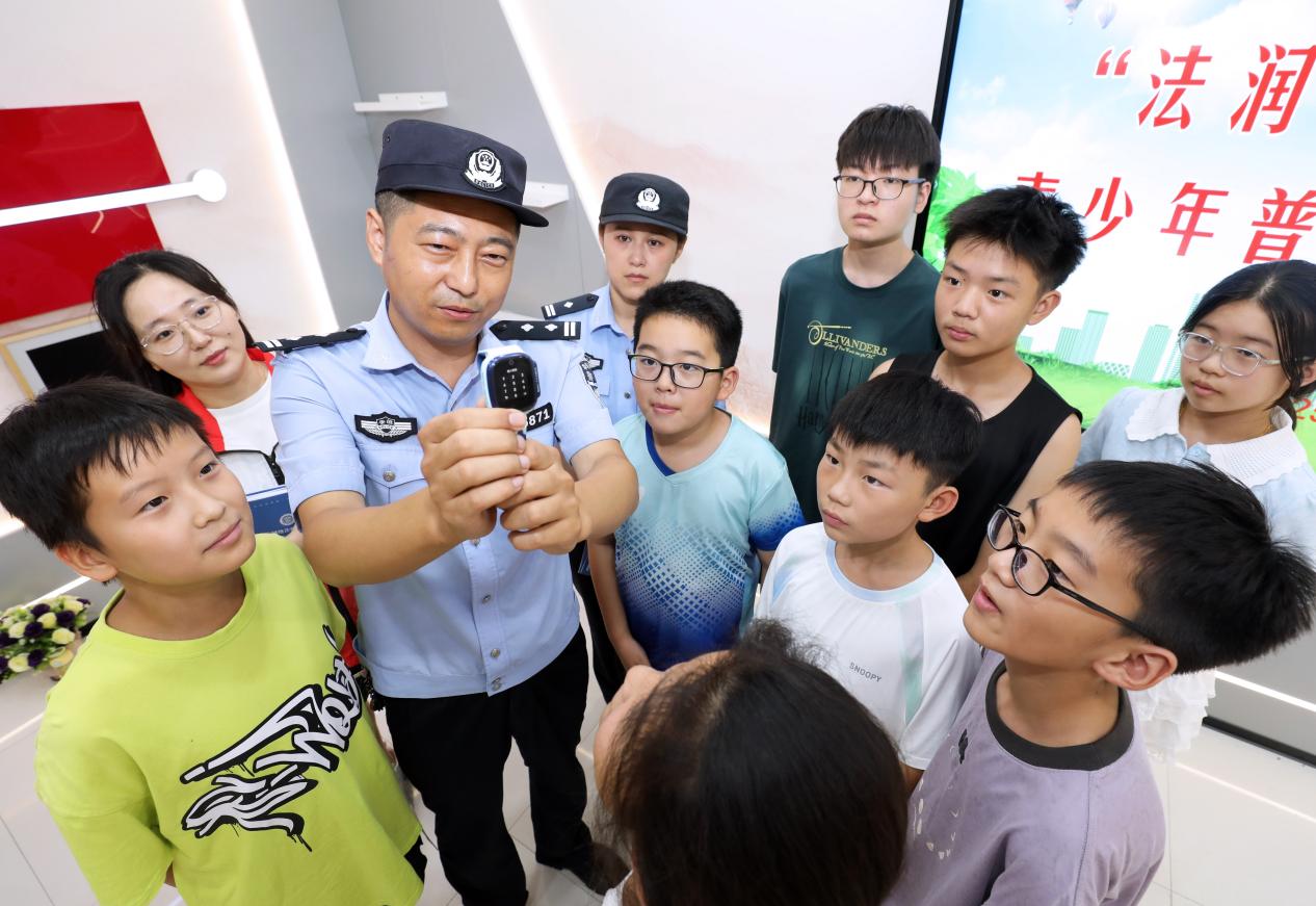 针对近期高发的儿童手表手机诈骗案例，民警和青年志愿者通过情景模拟，为孩子们讲解电话手表的诈骗方式和防范方法。李鑫摄