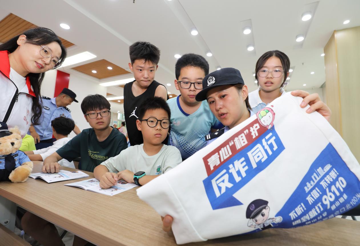 民警和青年志愿者正在为孩子们讲解防电信网络诈骗等知识。李鑫摄