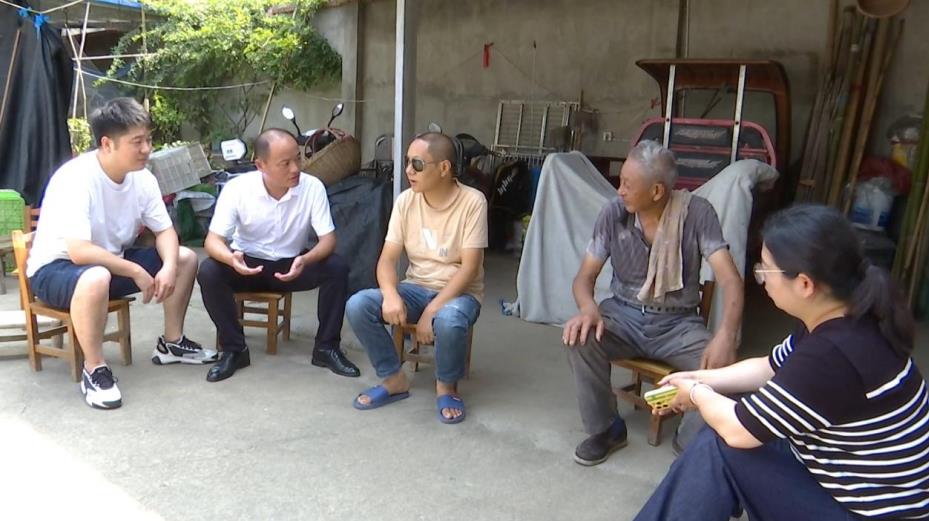 当地镇村干部上门进行服务，为残疾人许健解释有关政策。赵宇摄