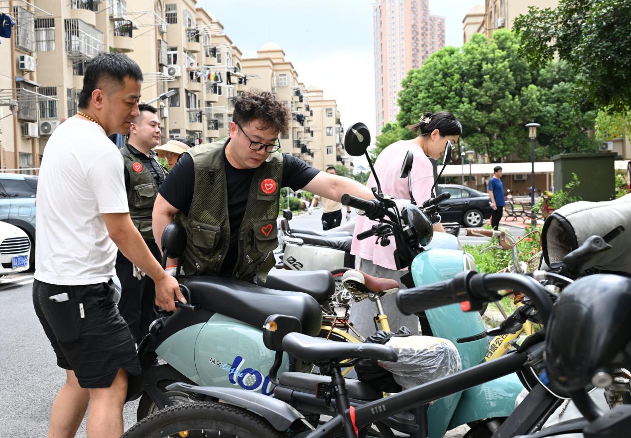 工作人员正在协助整治电动车摆放问题。莲花中心供图