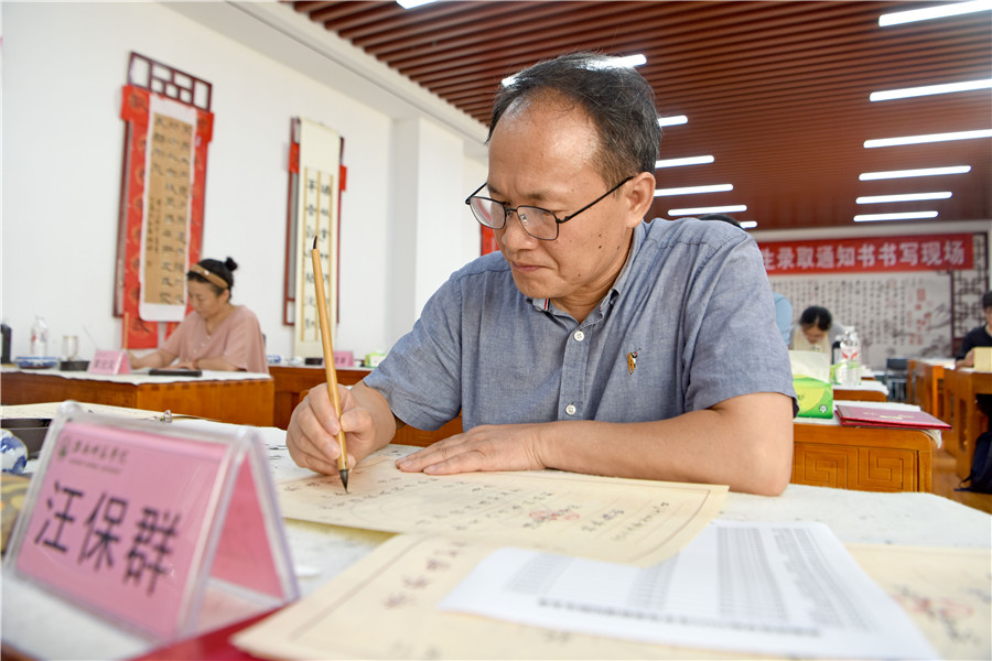 安徽淮南师范学院师生书法爱好者用毛笔为2025年录取新生手写录取通知书。