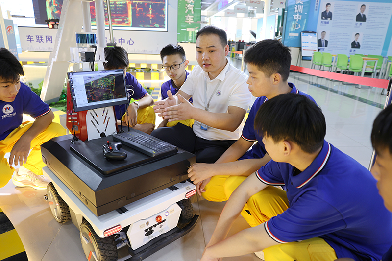 王明洋向学生传授智能网联无人驾驶车。万通汽车教育供图