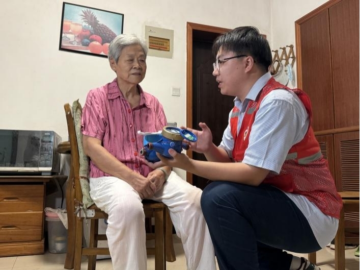 志愿者为独居老人讲解物联网智能水表工作原理。合肥水务集团供图