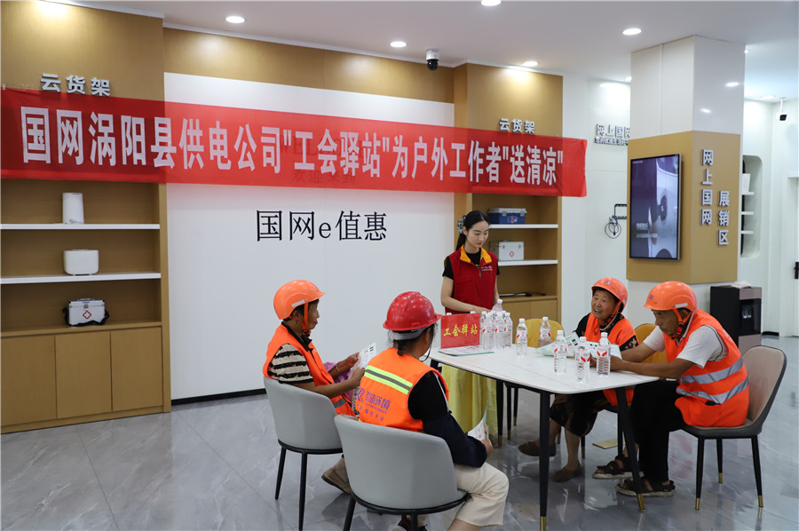 在国网涡阳县供电公司建设路营业厅“电力工会驿站”，工作人员正为环卫工人送上矿泉水解渴。