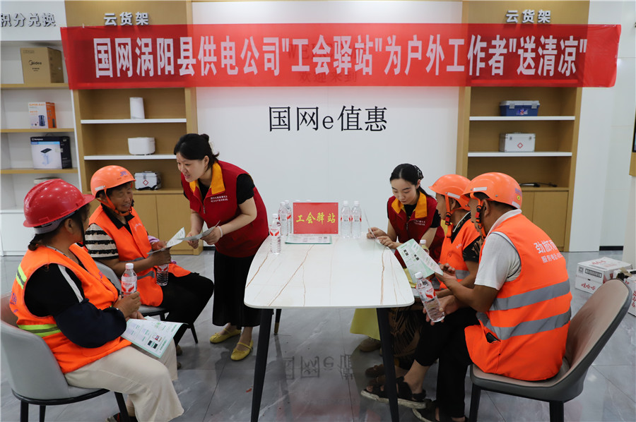 在国网涡阳县供电公司“电力工会驿站”，工作人员为环卫工人讲解夏日安全、节约用电知识。