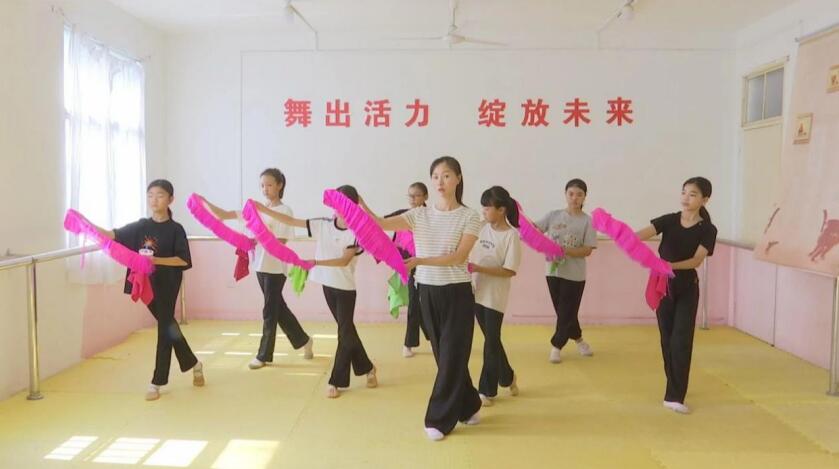 老师正在耐心地教授孩子们学习花鼓灯。