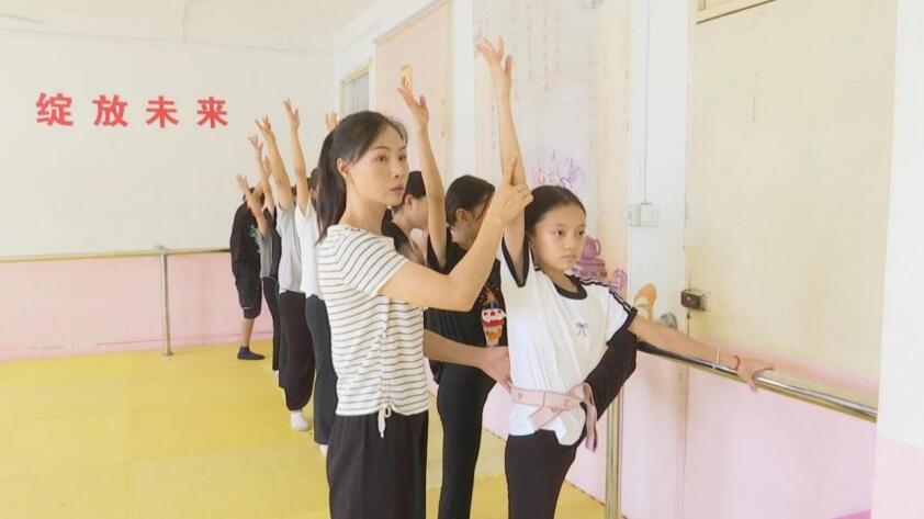 老师正在耐心地教授孩子们学习花鼓灯。