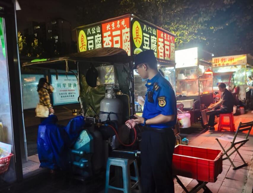 城管隊員對攤點安全檢查。