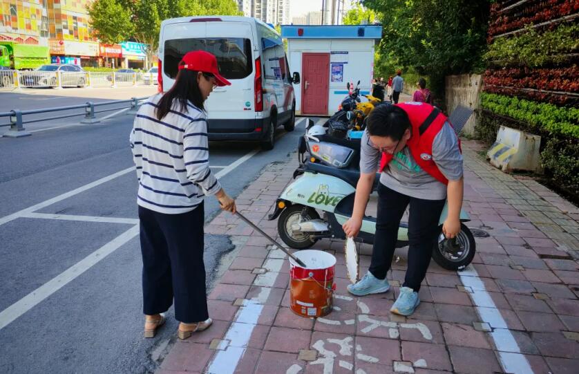 五裡墩街道志願者正在重新劃線，讓停車標識更清晰。