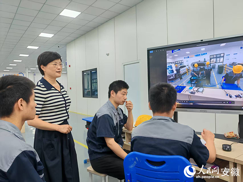 第二实训中心内,陈玉华指导在校备赛的学生。人民网 丁纪摄