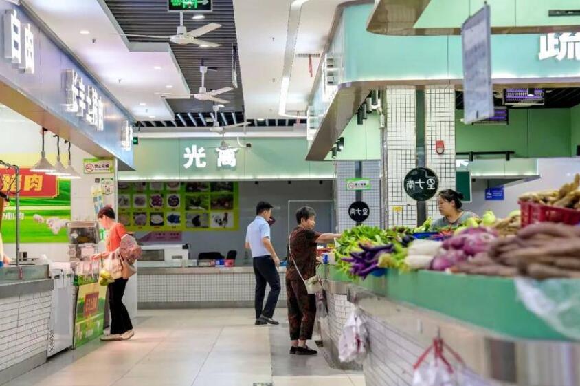 居民在金隅南七里邻里中心菜市场选购菜品。