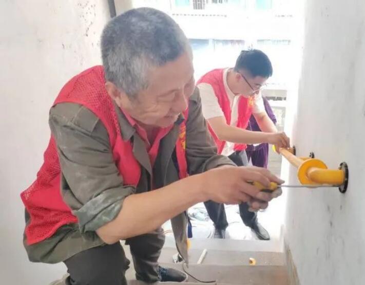 辖区志愿者为困难老人居住的小区楼道安装扶手。