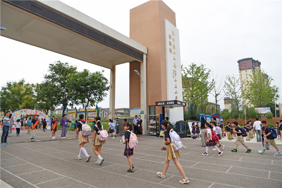 安徽省淮南市淮师附小山南第十五小学学生开心走进校园，迎接新学期到来。
