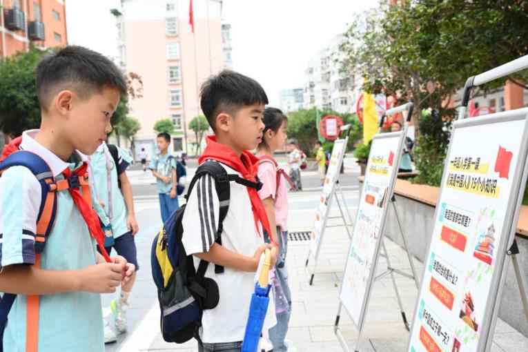 安全教育、爱国主义教育展板吸引学生们关注。杜刚摄