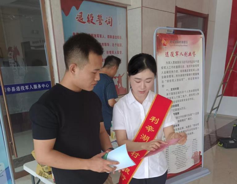 利辛湖商村镇银行工作人员为退役军人介绍“退役军人创业贷”。利辛县人社局供图