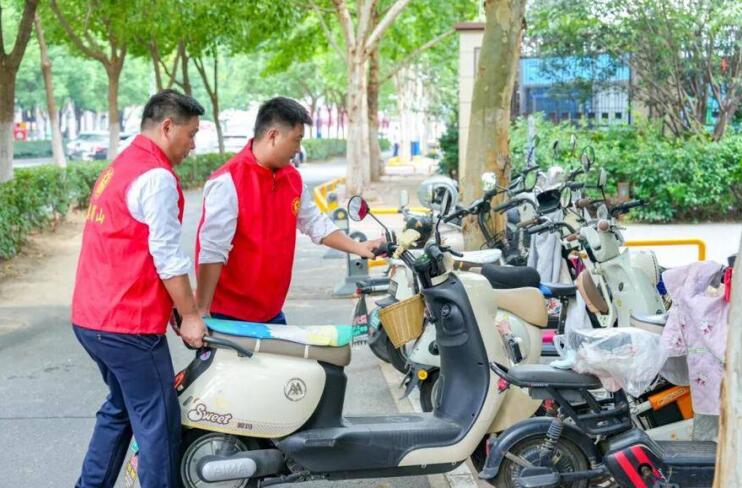 在肥西路與望江西路交口，志願者將非機動車擺放整齊。