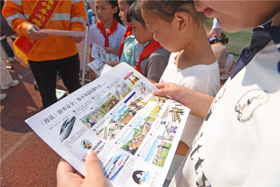安徽淮南市高新区玉兰小学学生通过铁路部门发放的安全漫画学习铁路安全知识。陈彬摄