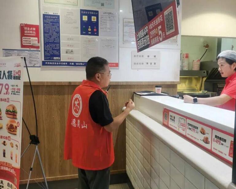 党员志愿者向企业宣传食品安全相关法律法规。