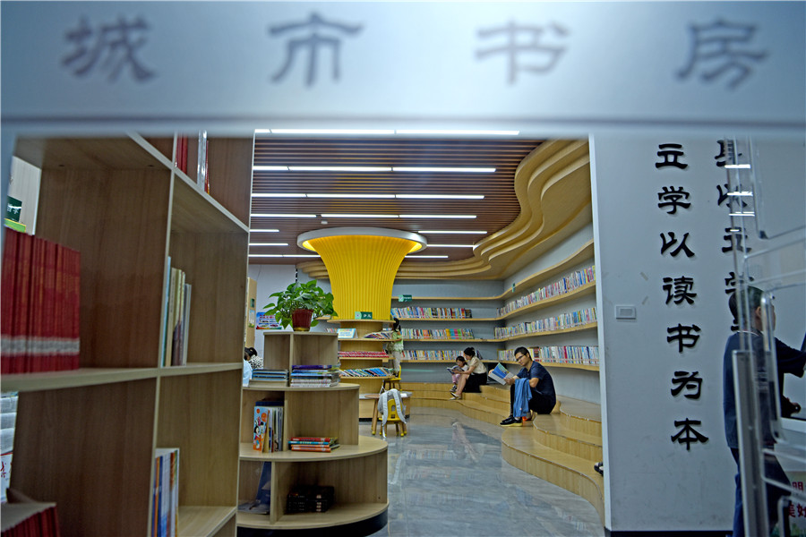 安徽省淮南市田家庵区市民利用晚间休息时间在家门口的城市书房中享受阅读。