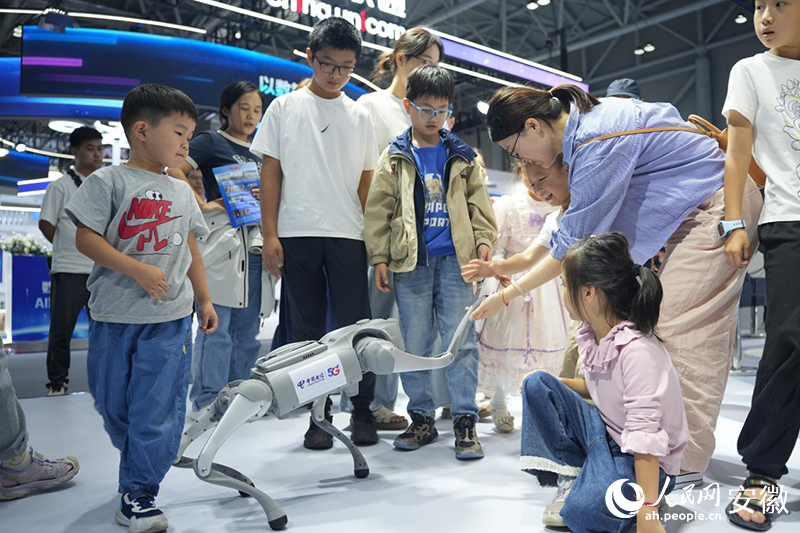 观众与中国电信展区内机器狗进行互动。人民网记者 王锐摄
