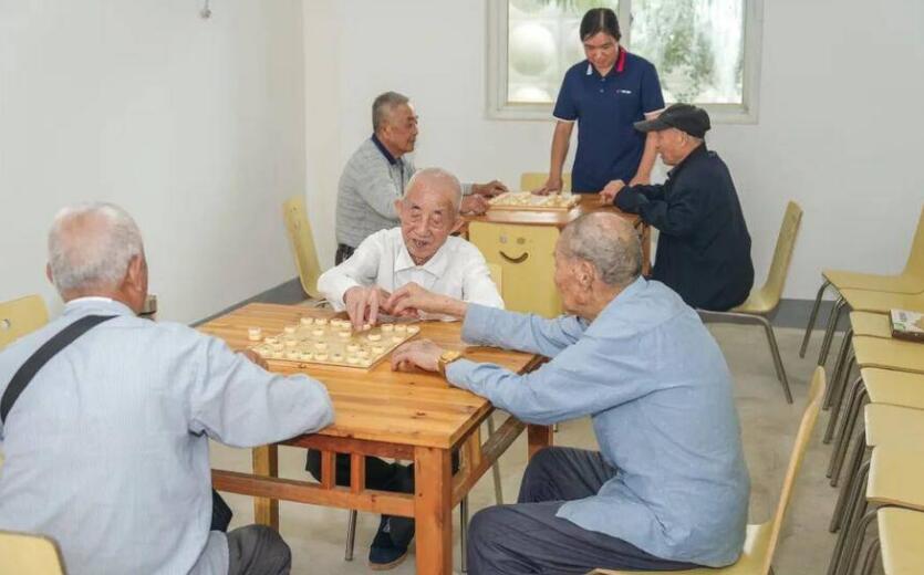 活动室内,几位老人对弈正酣,不时传来欢声笑语。