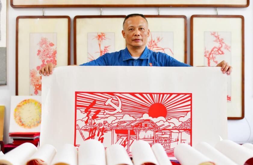 陈国斌展示创作的剪纸作品《红船精神》。