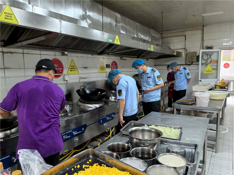 执法人员对饭店后厨进行检查。