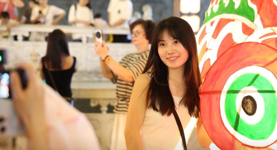 游客和鱼灯合照。