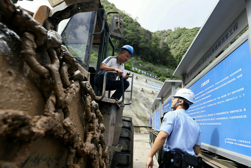 程安逸（右）在辖区重点项目建设现场开展安全宣防。高鹏摄