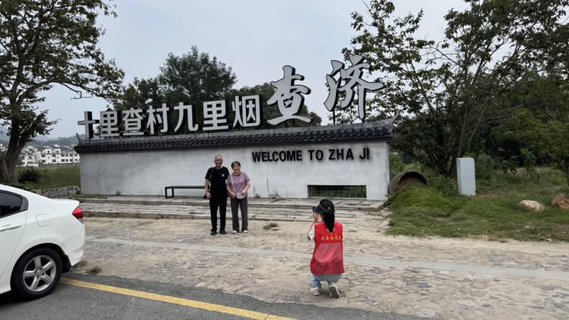 查濟風景區，志願者主動為游客拍攝合影.