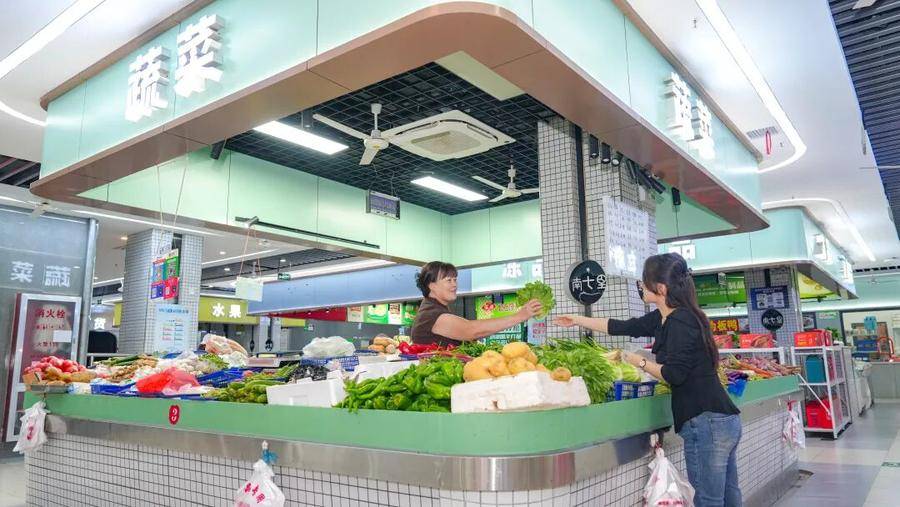 居民在金隅南七里菜市场选购菜品。