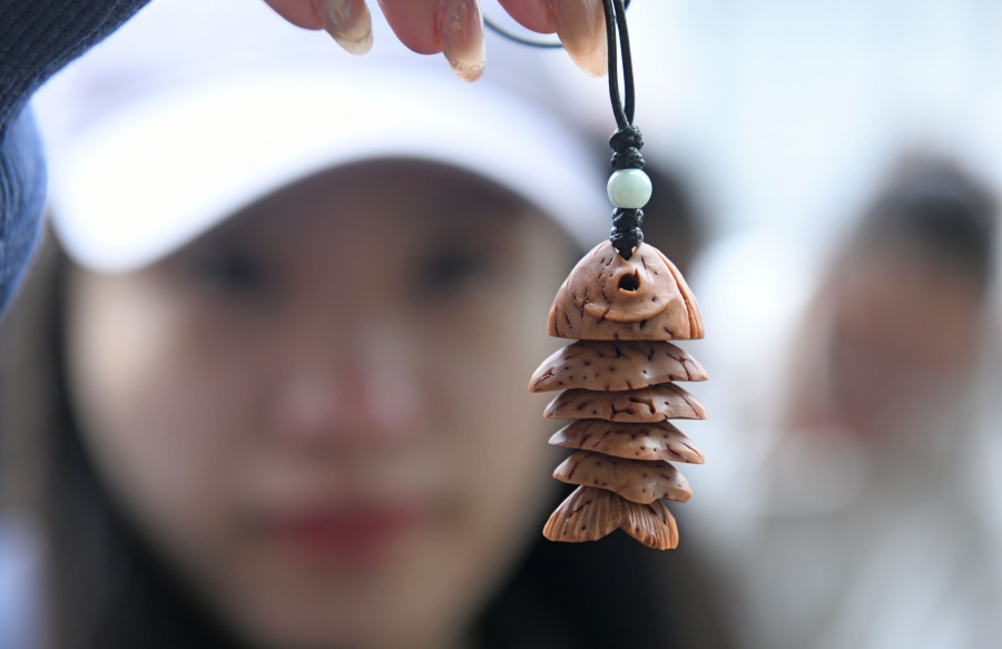一名游客选购当地核雕文创产品。