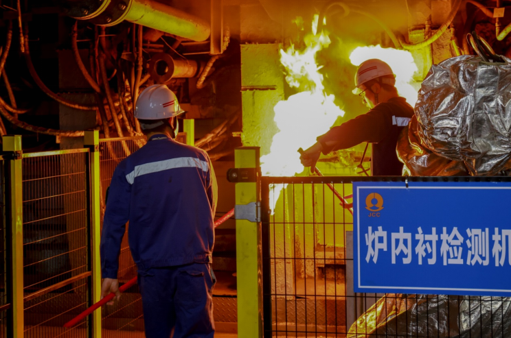 两名火种采集人员从金隆铜业闪速炉中采集火种。 储著传摄