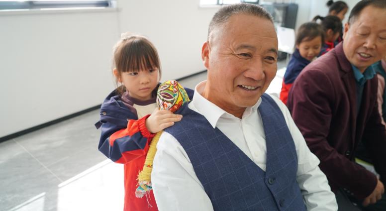 孩子们用“艾草锤”给老人们捶背捶腿。