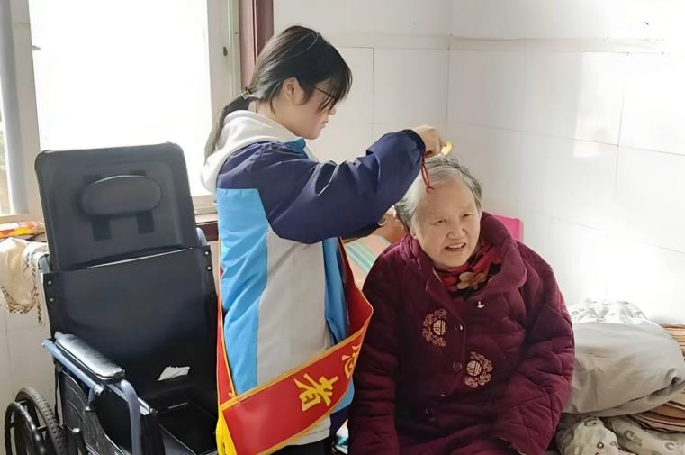 青年志愿者为老人梳头。