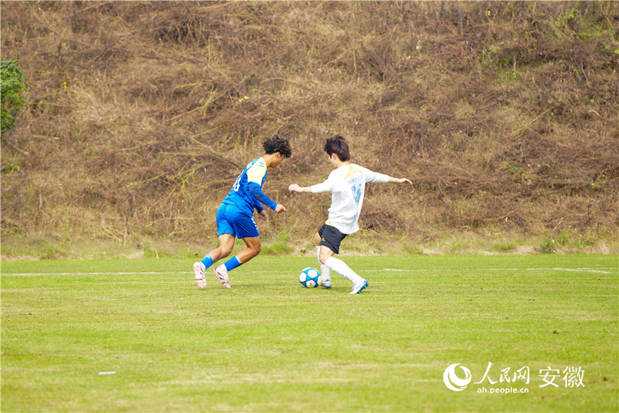 两位足球运动员正在激烈拼抢。人民网记者 王锐摄