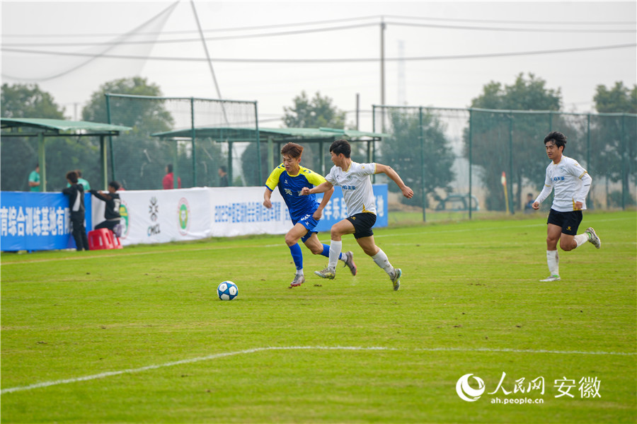 绿茵场上球员正在激烈拼抢。人民网记者 王锐摄