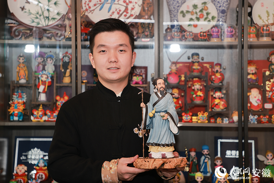 梁岗子展示自己的作品——华佗采药。人民网记者 王晓飞摄